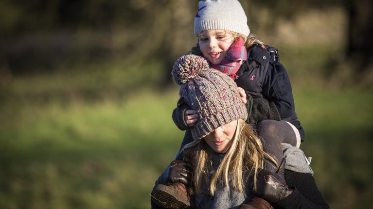 Woman giving child a piggyback